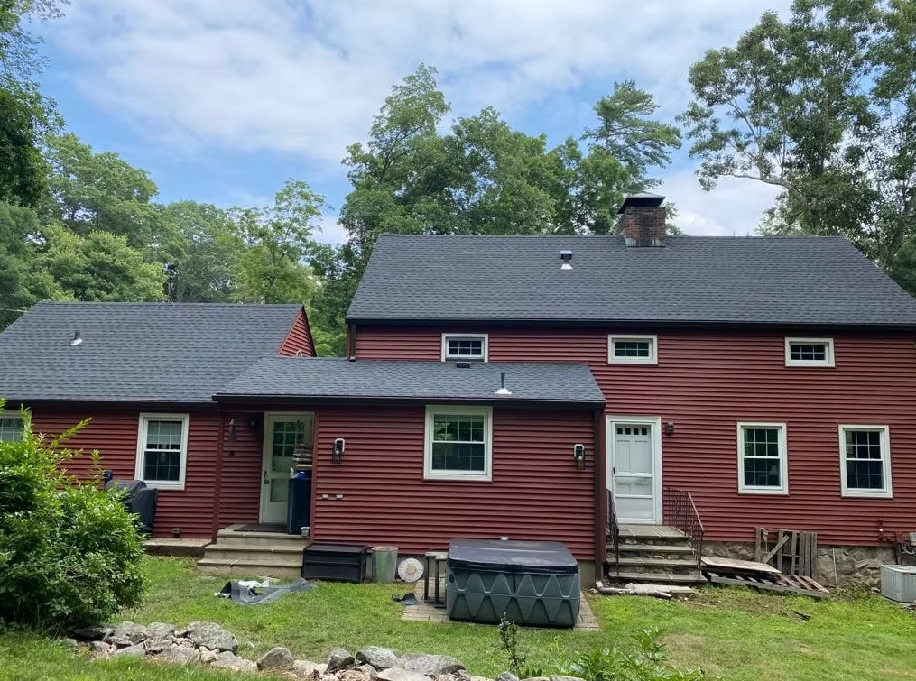 Completed charcoal asphalt shingle roof on a red-sided home in Fairfield County, Connecticut
