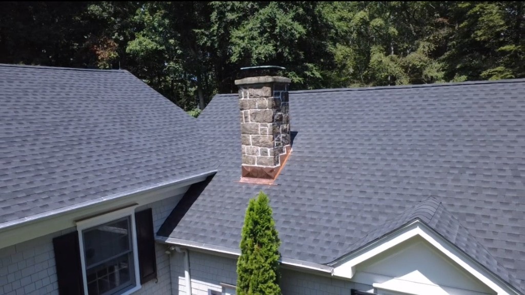 New copper chimney flashing and cricket installed on architectural shingle roof in Fairfield County, CT